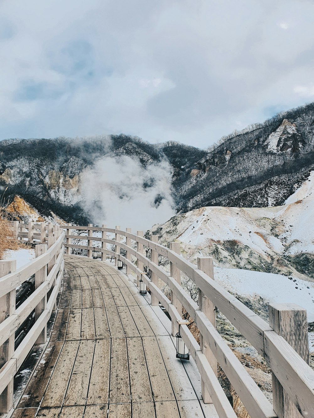 brown wooden fence near snow covered mountain during daytime