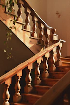 A warm wooden staircase with natural light highlighting the craftsmanship.