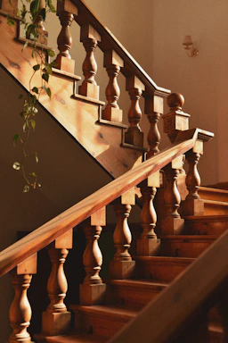 A warm wooden staircase with natural light highlighting the craftsmanship.