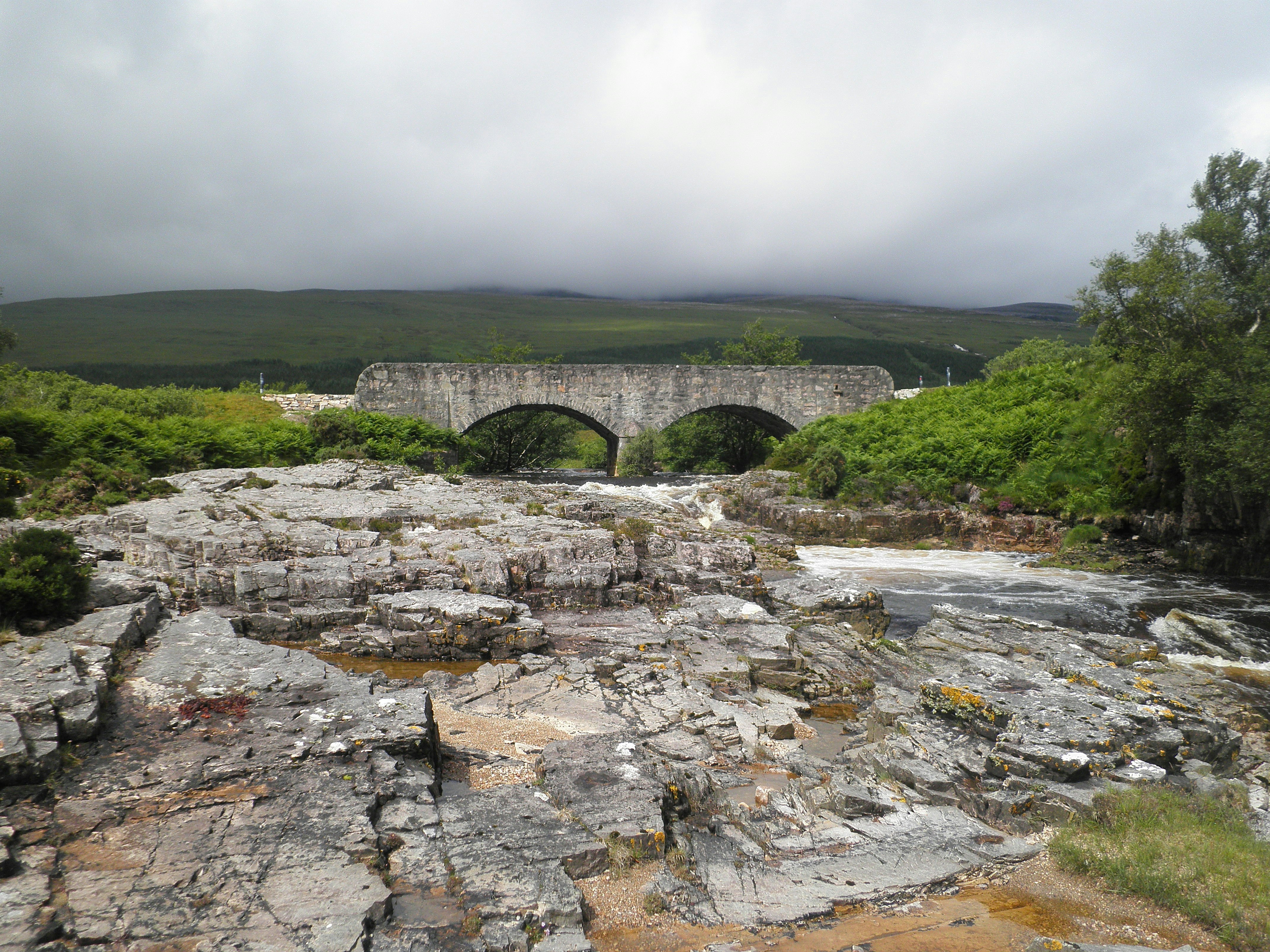 Graue Betonbrücke über den Fluss