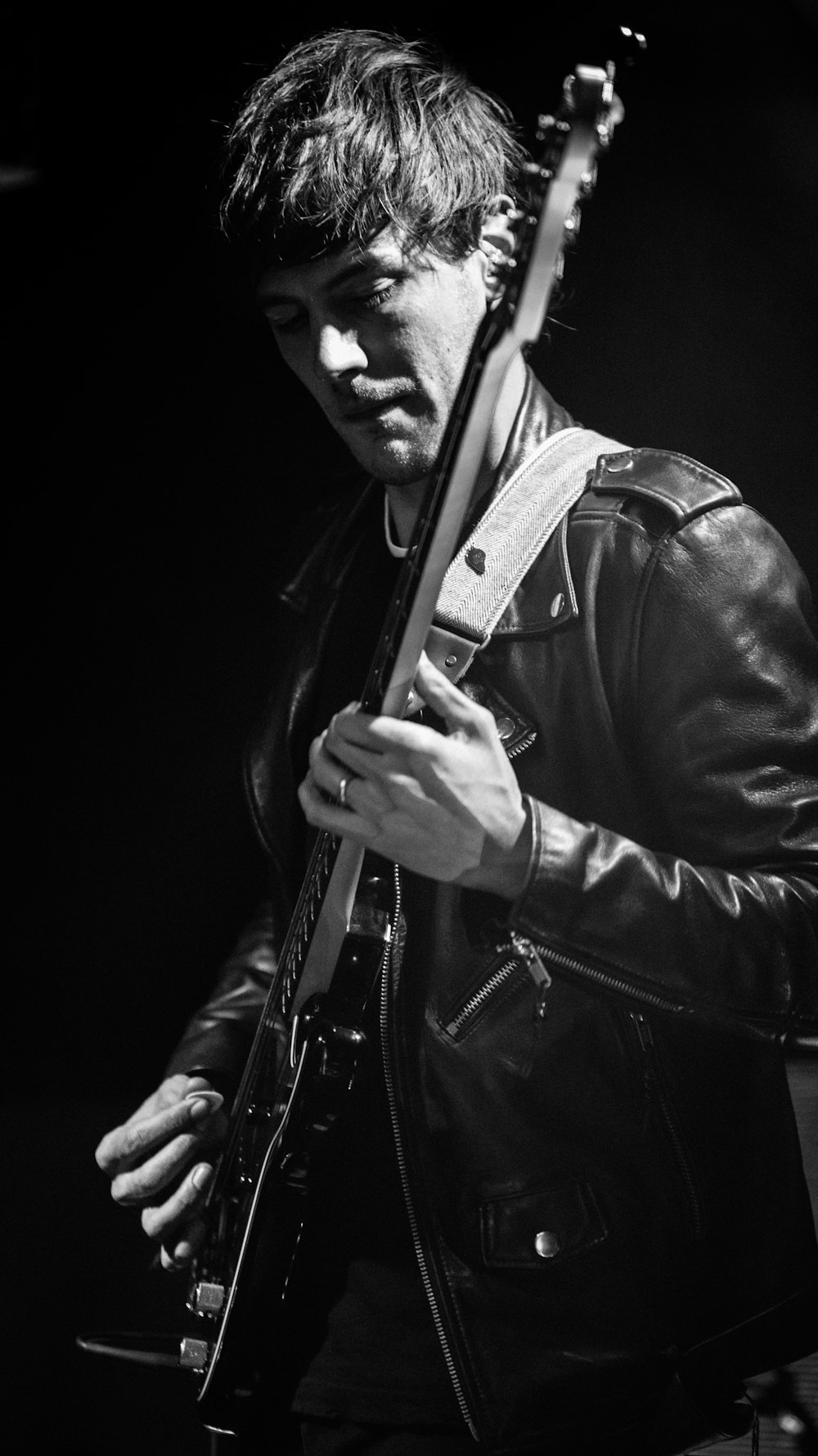man in black leather jacket holding guitar