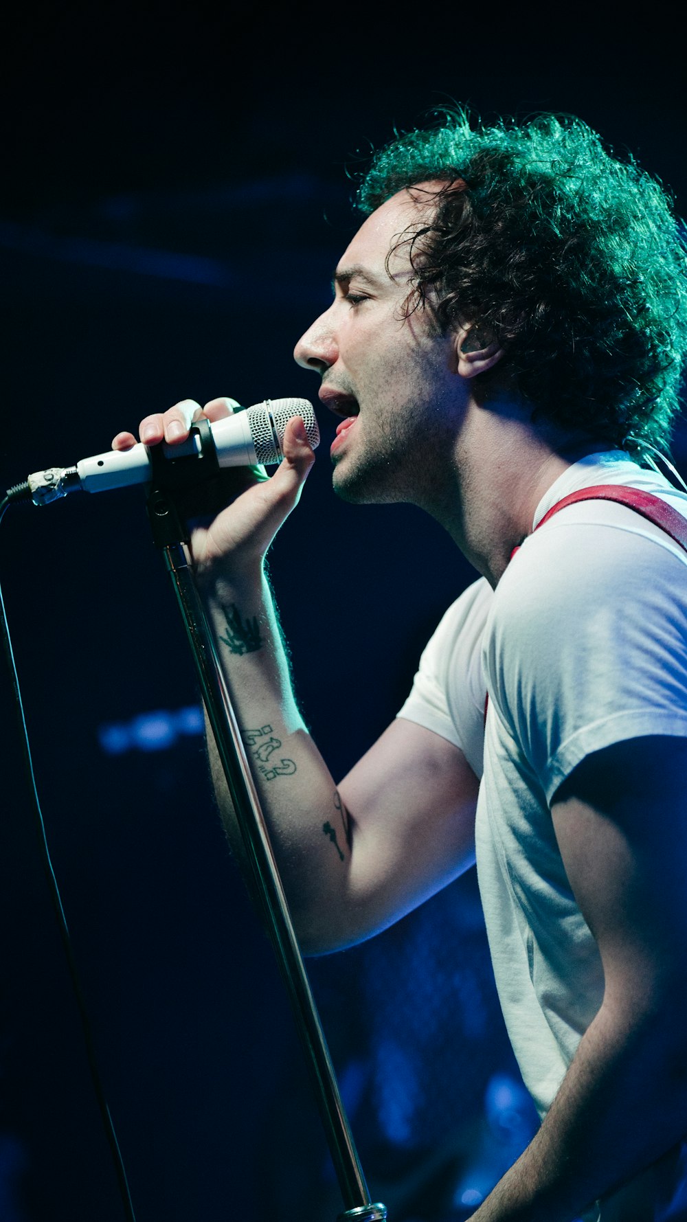 man in gray tank top singing