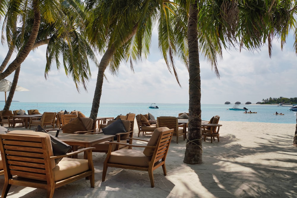 Sillas y mesa de madera marrón en la playa durante el día