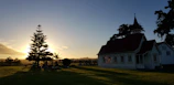 A peaceful sunset behind the church building, symbolizing hope and faith.