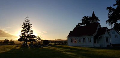 A peaceful scene of the Salley Baptist church building at sunset with warm light glowing.