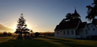 A peaceful church exterior at sunset with welcoming lights.