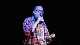 man in red white and blue plaid dress shirt wearing black sunglasses