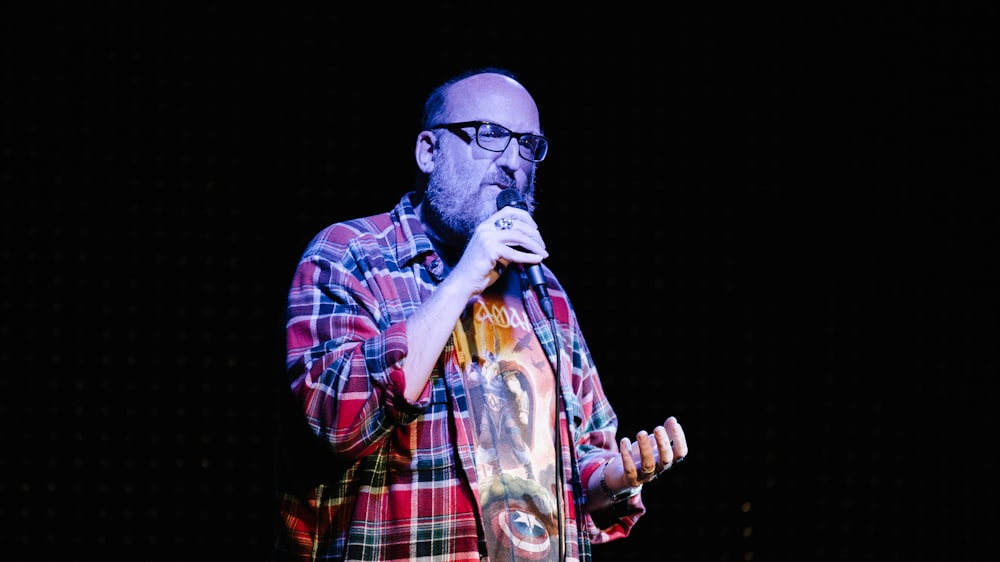 man in red white and blue plaid dress shirt wearing black sunglasses