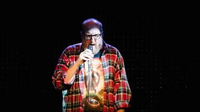 man in red white and black plaid button up shirt singing