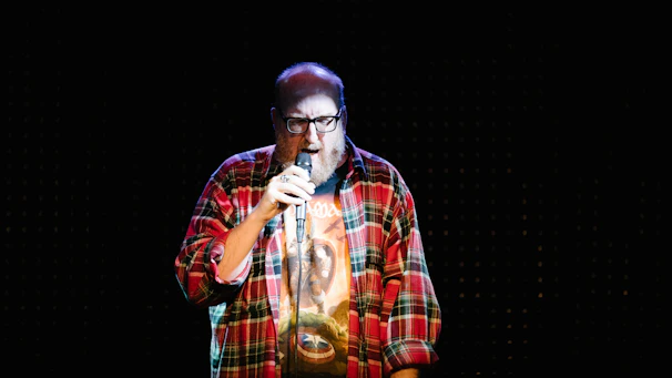 man in red white and black plaid button up shirt singing