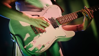 person playing white and brown stratocaster electric guitar