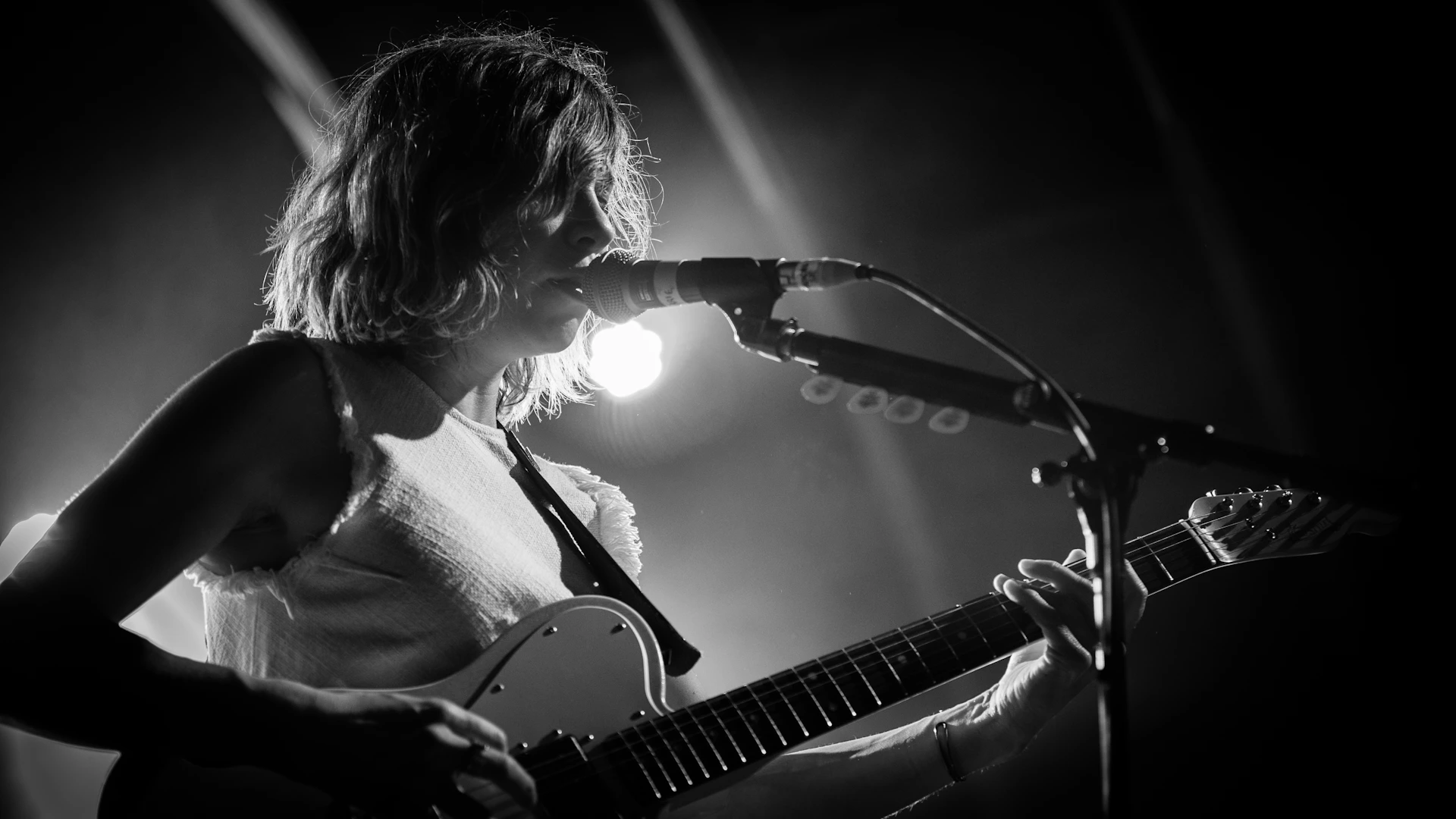 woman playing guitar in grayscale photography