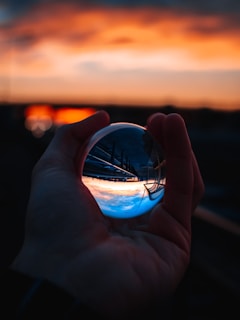 person holding clear glass ball