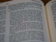 A close-up of a page with a highlighted passage and a pair of reading glasses.