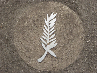 Ornamental concrete medallion mounted on an exterior wall.