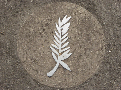 Ornamental concrete medallion mounted on an exterior wall.