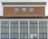 Facade of a multi-storey building with a symmetrical arrangement. The upper section features a brick texture and three evenly-spaced windows. Below, a larger section displays green tiling and numerous windows framed with wood.