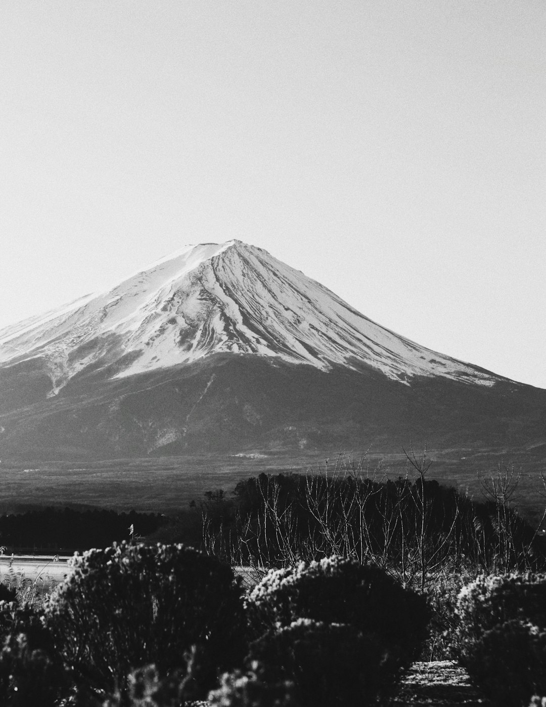 grayscale photo of mountain under cloudy sky