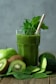 green liquid in clear drinking glass with straw