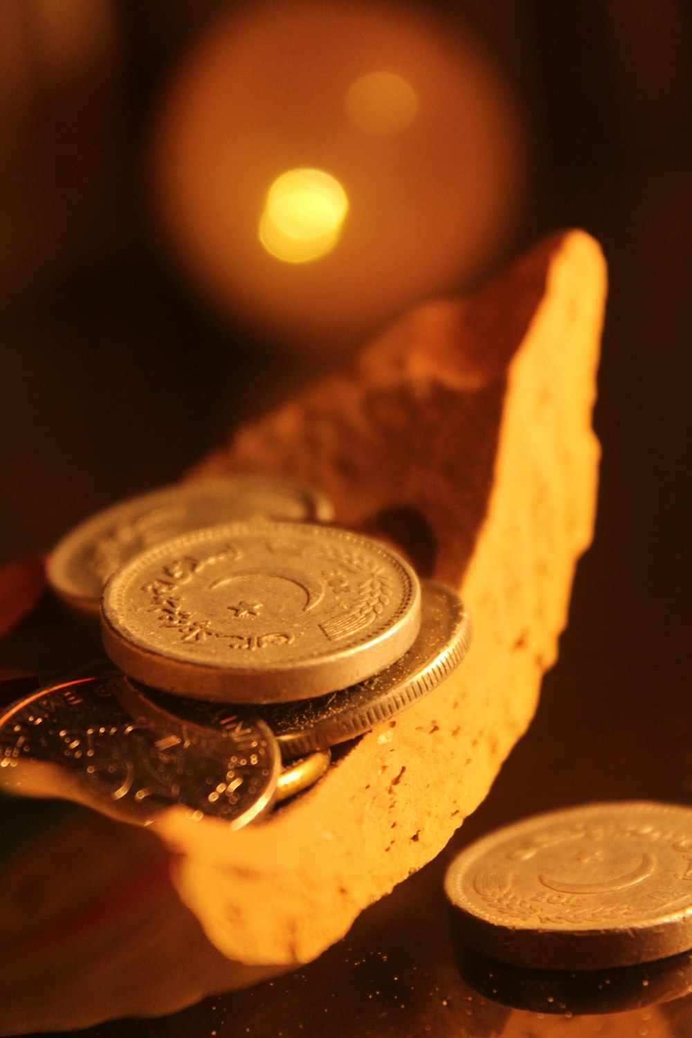 silver round coin on brown wooden surface