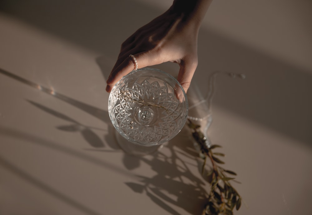 person holding silver round ornament