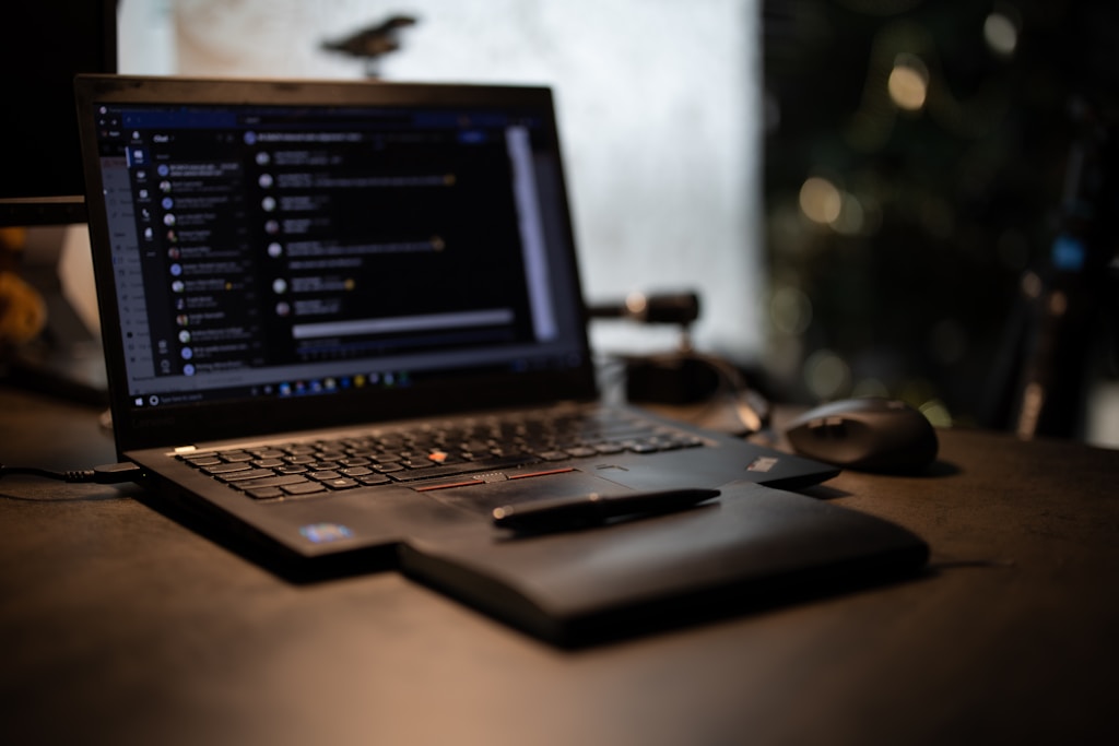 black laptop computer on brown wooden table