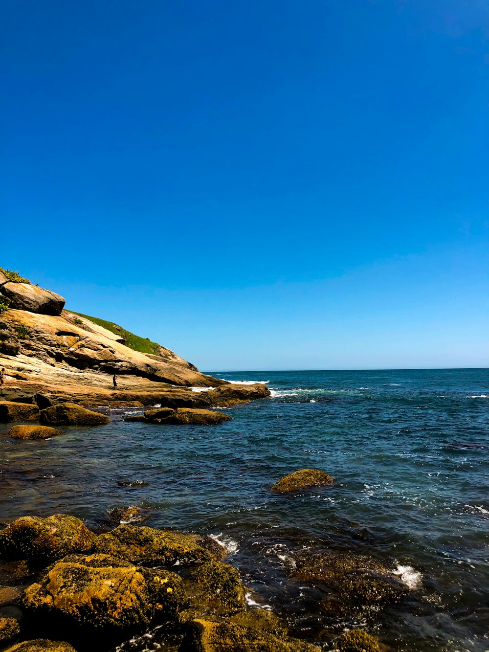 brown rock formation near body of water during daytime