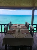 A beautifully set dining table overlooking the ocean.