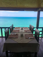 Dining area set up for an evening meal overlooking the tranquil sea.