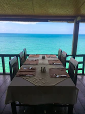 Guests enjoying a gourmet dinner on a beautifully set deck overlooking the ocean.