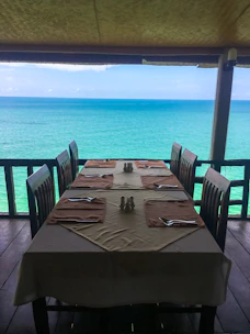 Guests enjoying a gourmet dinner on a beautifully set deck overlooking the ocean.