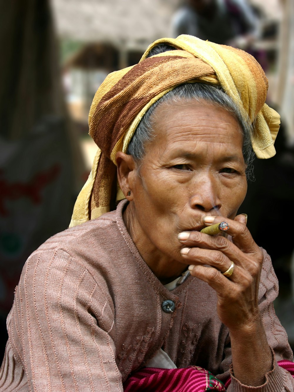 茶色のヒジャーブをかぶった女性が緑の果物を食べる