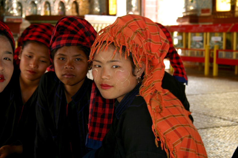 woman in black jacket beside woman in orange scarf