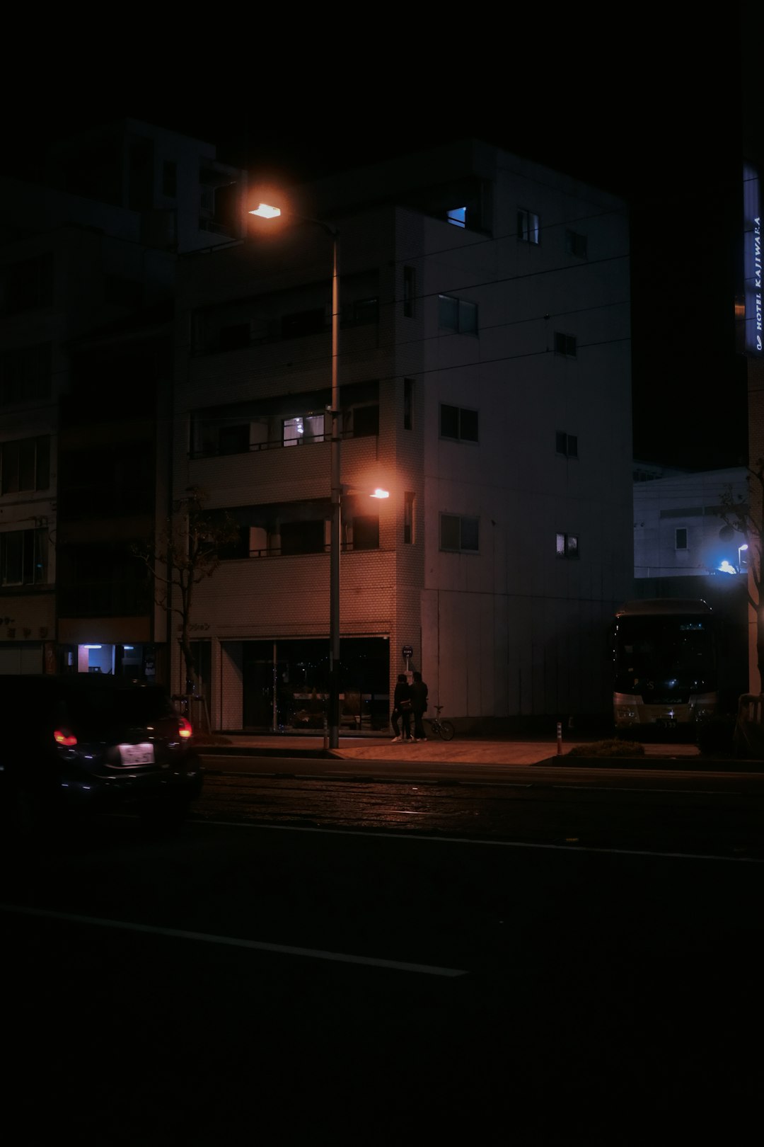 cars parked in front of white building during night time