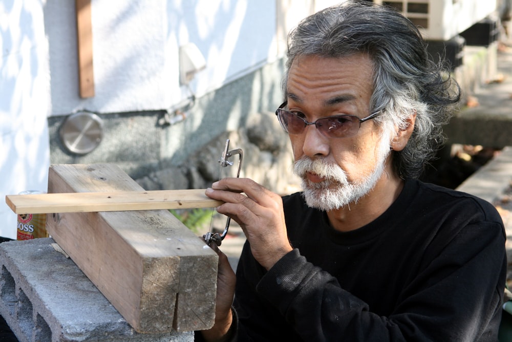 man in black sweater holding gray metal bar