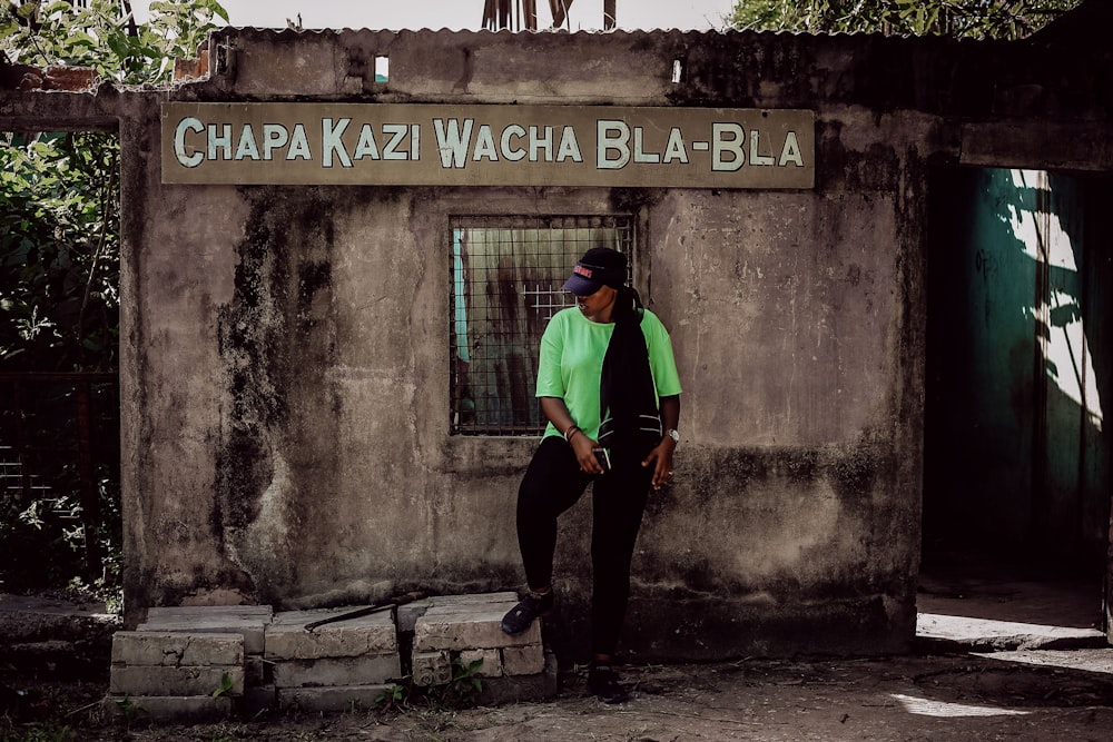 Foto de hombre con camisa verde y pantalón negro parado al lado de una  pared de concreto gris – Imagen gratuita Kisarawe en Unsplash