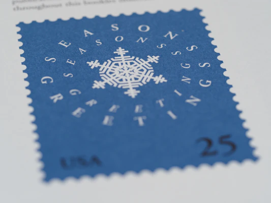 A hand holding a commemorative USPS stamp celebrating a famous American landmark.