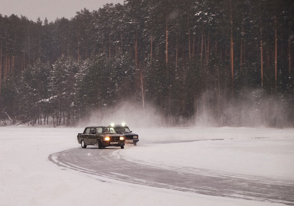 black car on snow covered road during daytime