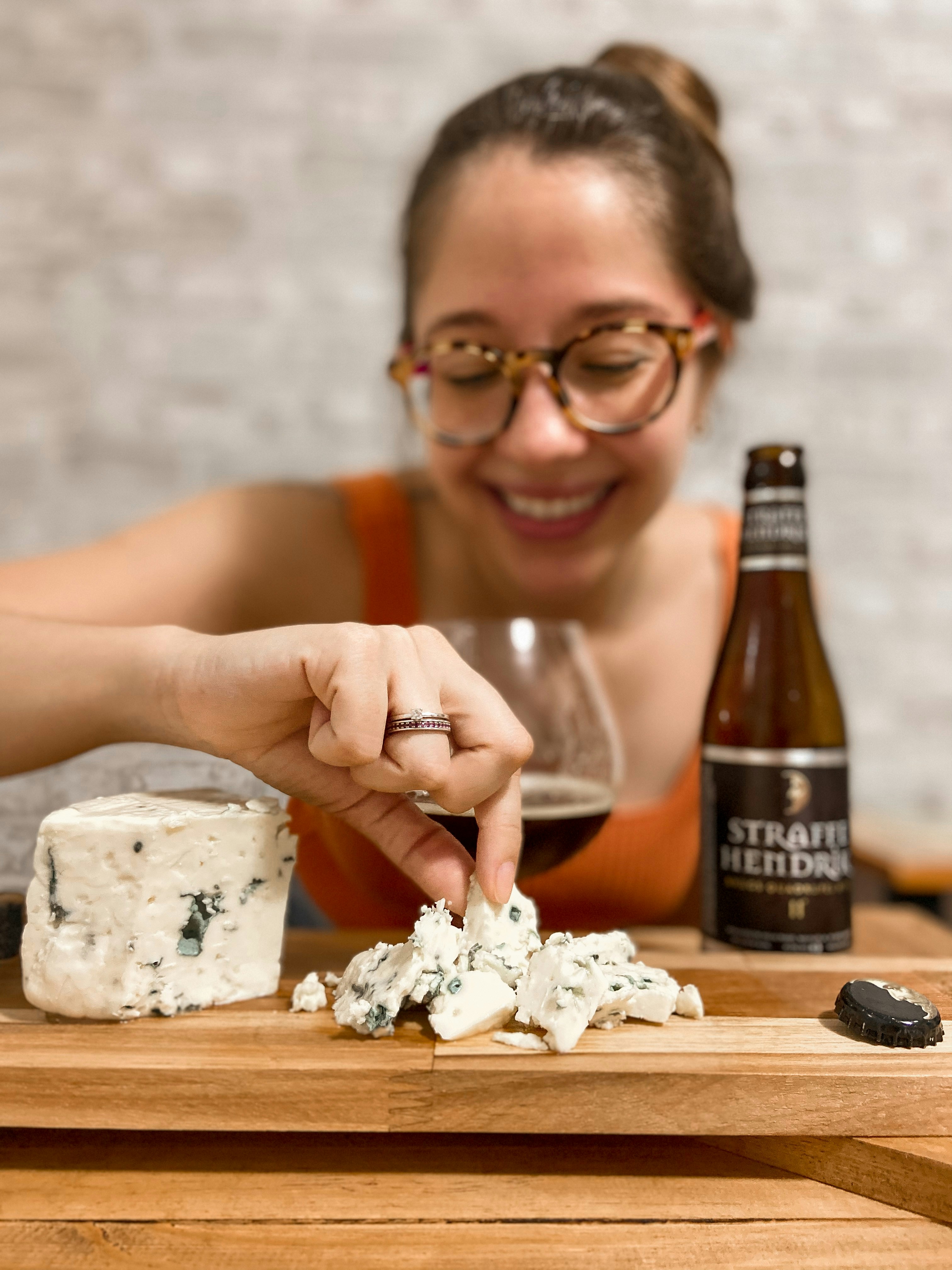 man in black framed eyeglasses holding brown glass bottle