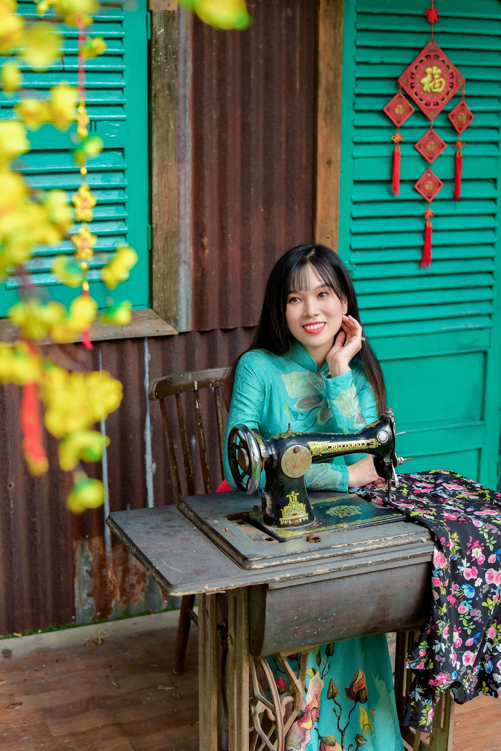 woman in pink shirt sitting beside black sewing machine