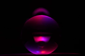 purple and pink ball on black surface
