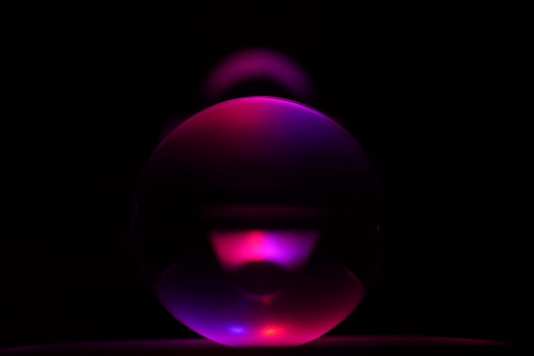 purple and pink ball on black surface