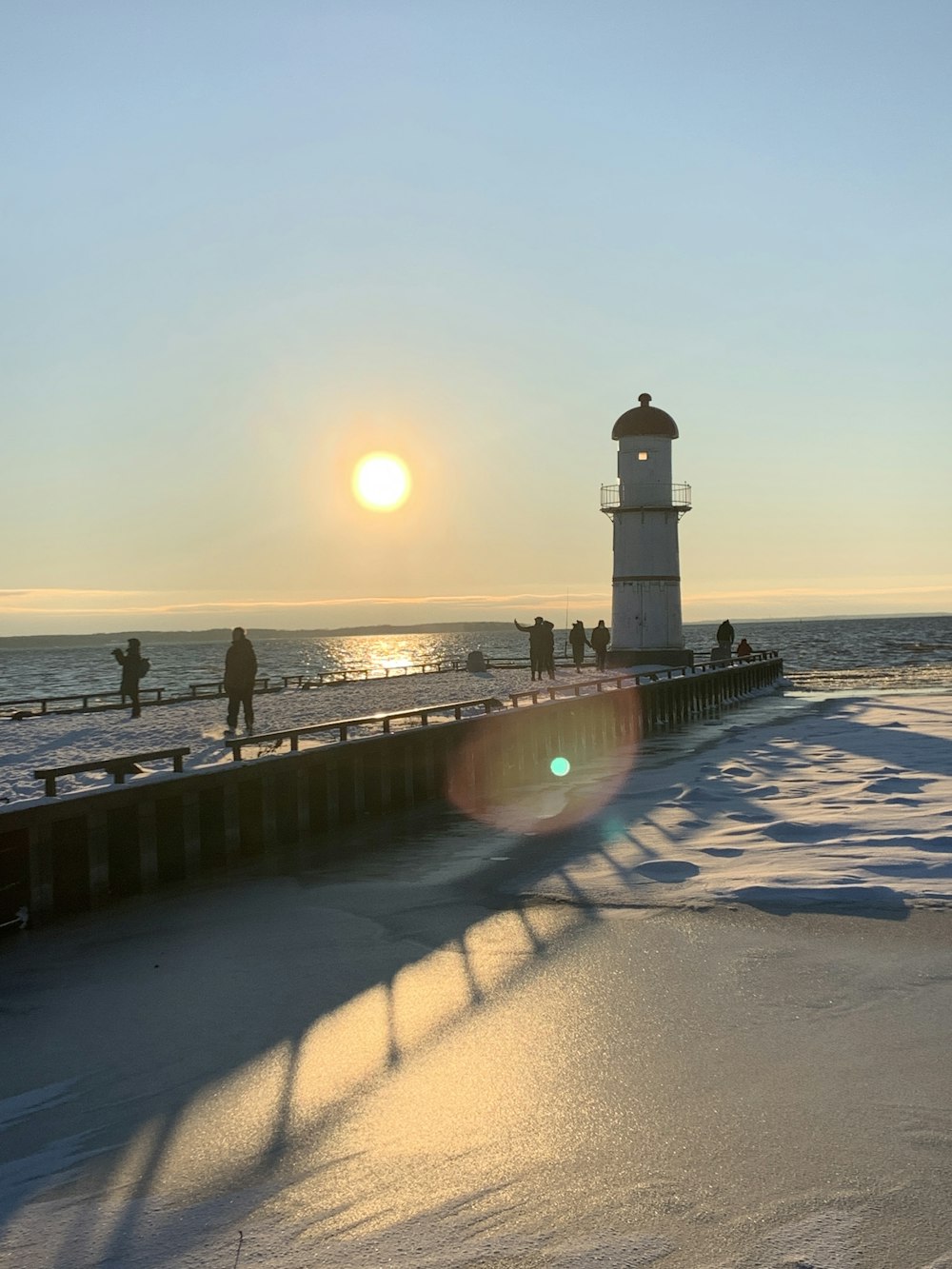 white lighthouse near body of water during sunset