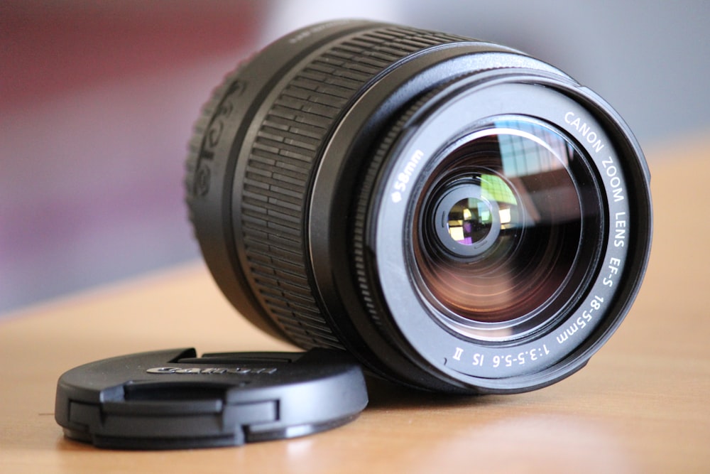 black camera lens on brown wooden table