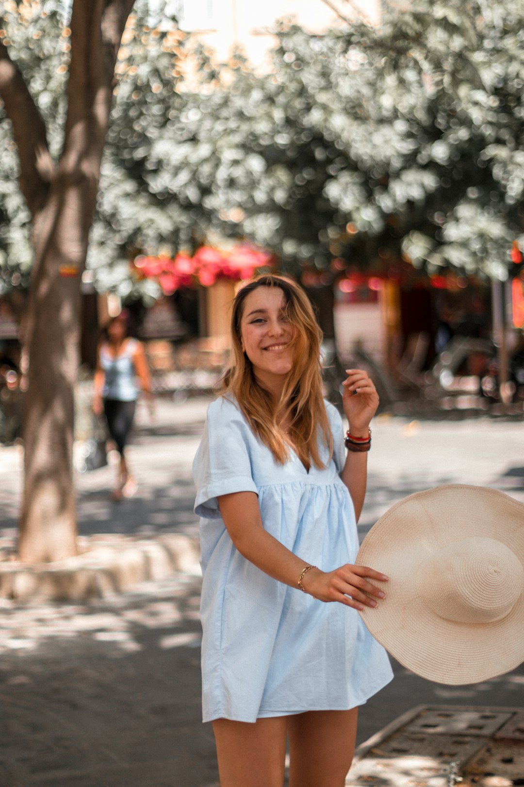 woman in white button up shirt standing on street during daytime