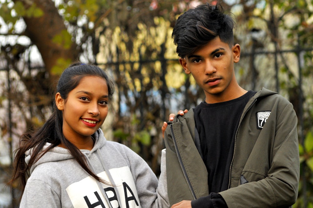 man in black crew neck shirt beside woman in gray hoodie