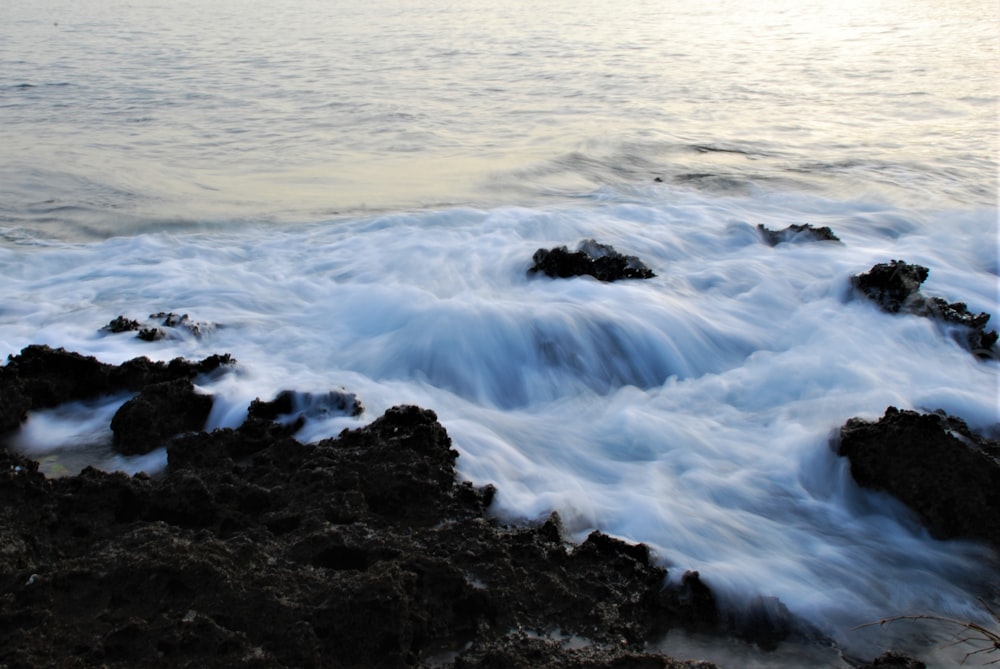 ocean waves crashing on rocks during daytime