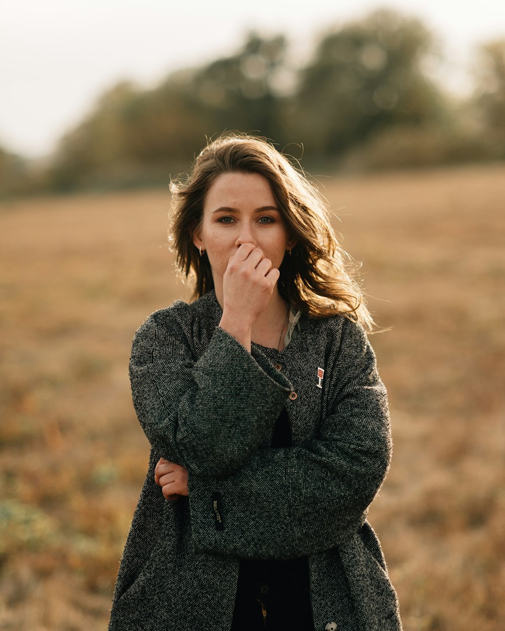 woman in black long sleeve shirt standing on brown grass field during daytime