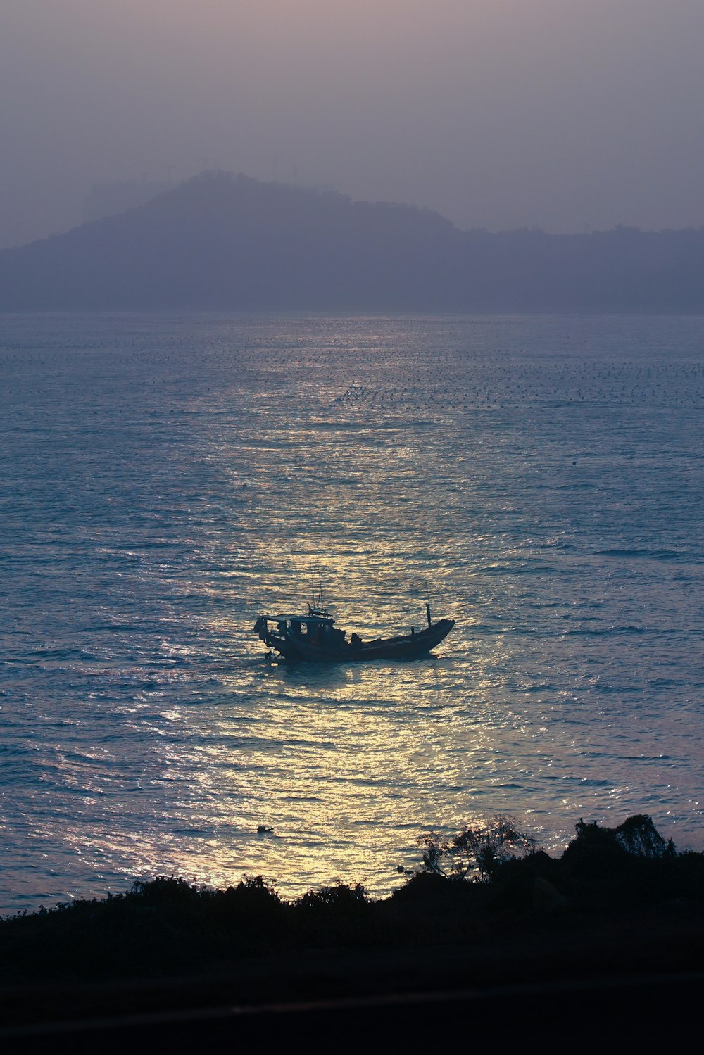 silhouette of boat on sea during daytime
