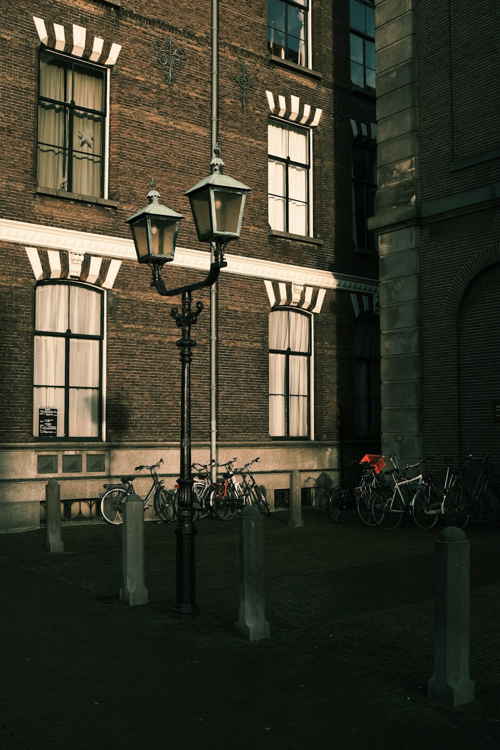 lampadaire noir près d’un bâtiment en béton brun pendant la journée